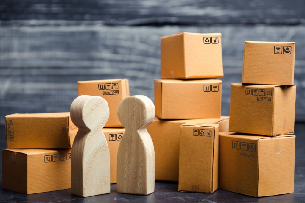 Wooden figures of people surrounded by boxes in the concept of storage solutions