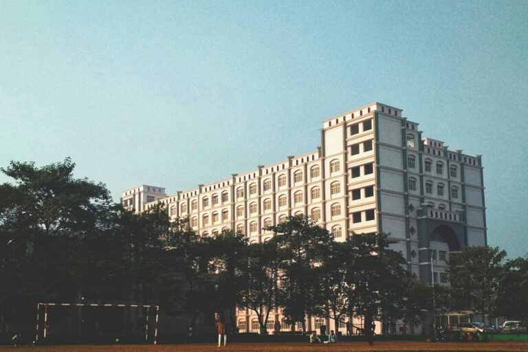 A huge school building with a football field in the concept of 'top schools in Chelsea'.