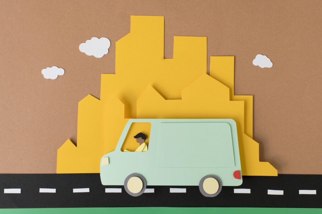 Paper cutout representing a man and a van for long-distance move with residential buildings in the background in the concept of 'can you use a man and van service for long distance moves'.