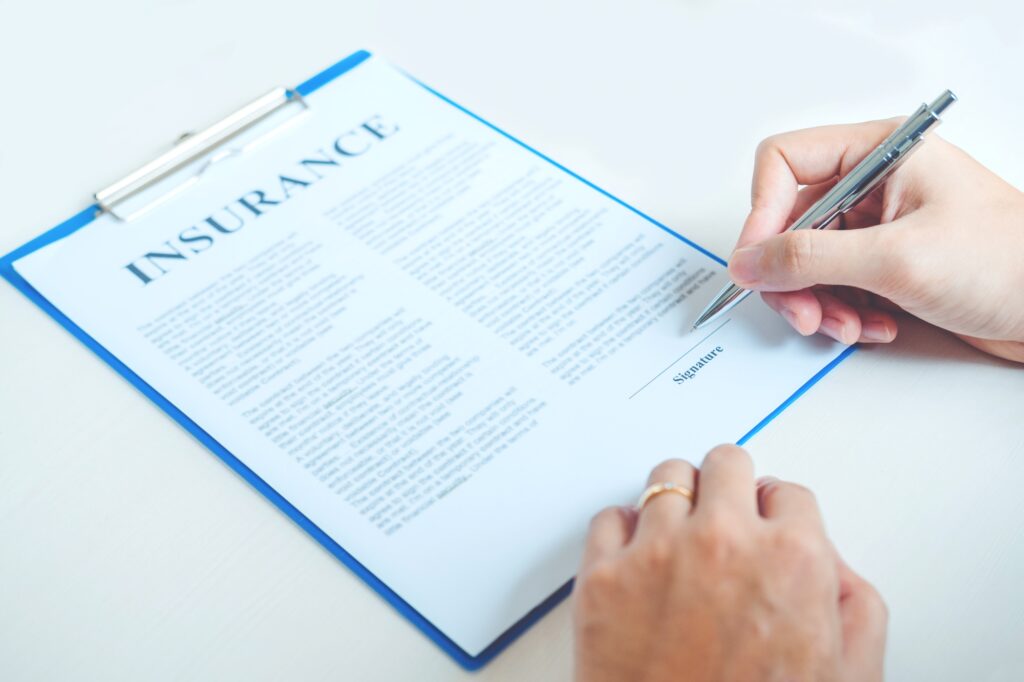 Cropped image of a woman signing an insurance policy